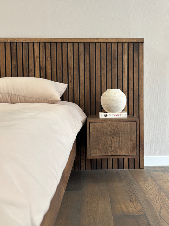 Massief houten bed wat perfect aansluit bij japandi interieur met beige beddengoed van Egyptisch katoen